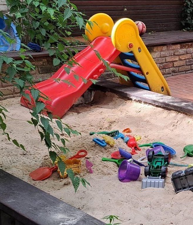 Bunte Förmchen und Spielzeugbagger im Sand